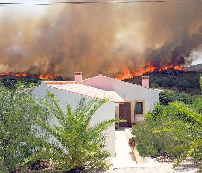 Wildfire burning near a home.